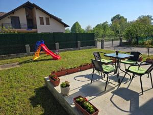 a patio with a table and chairs and a playground at Apartman Nia in Bihać