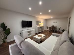 a living room with a couch and a flat screen tv at La caprichosa in Chiclana de la Frontera