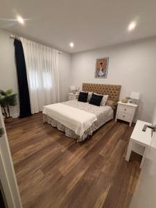a bedroom with a bed and a wooden floor at La caprichosa in Chiclana de la Frontera +62 photos
