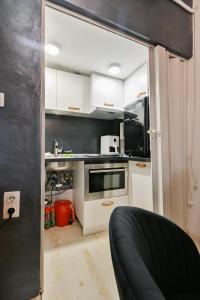 a kitchen with white cabinets and a black wall at Luxory in Sofia