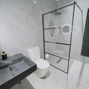 a bathroom with a toilet and a pair of glasses at Mo's urban nest - with power backup in Sandton +20 photos