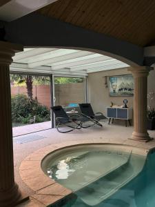 a pool in a patio with chairs and a table at Osiris Espace Piscine couverte et Chauffée in Mesves-sur-Loire +8 photos