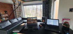 a living room with two laptops on a desk at OFF Chata na Oślaku, Jacuzzi & Sauna in Jaworzna