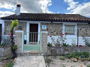 a small stone house with a green door at La casa vieja de Marchenilla in Jimena de la Frontera
