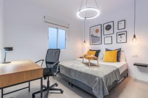 a bedroom with a bed and a desk and a table at El Submarino Coastal Home in Santa Maria de Guia de Gran Canaria