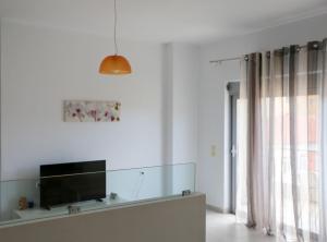 uma sala de estar com uma TV de tela plana na parede em Apartments Piazza em Himare