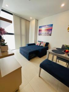 a living room with a blue couch and a table at Comfortable apartment near the beach in Playa Bello Horizonte +14 photos