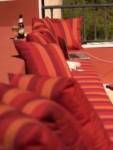 a couch with a laptop and a glass of wine at Hotel Cala Sant Vicenç - Adults Only in Cala de Sant Vicenc