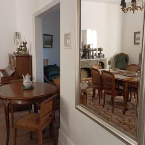 a dining room with a table and a mirror at Demeures ressourçantes - Le Vallon in Saint-Martin-de-Saint-Maixent