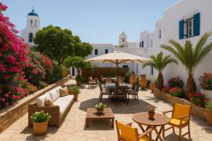 a patio with furniture and tables and chairs and flowers at Virginia Studios in Tinos