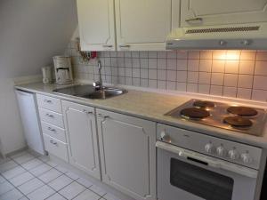 Η κουζίνα ή μικρή κουζίνα στο Ferienwohnung-Nils-Holgerson-mit-Balkon-zwischen-Strand-Wald-Wiese-im-Suedosten-der-Insel-Ruegen