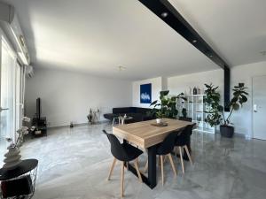 Una sala de estar con una mesa y sillas de madera. en Montpellier Un écrin de lumière pour enchanter votre séjour, en Montpellier