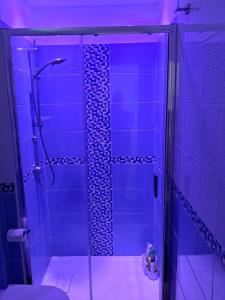 a bathroom with a glass shower with purple lighting at Casa Acquamarina in Marina di Monasterace +33 photos