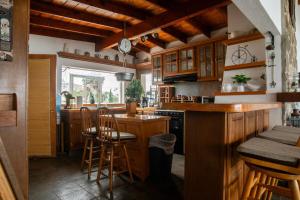 a kitchen with wooden cabinets and a bar with stools at Las Tres Banderas Beach House in San Miguel