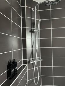 a shower in a bathroom with black and white tiles at Appart Duplex Proche Centre in Amiens +31 photos