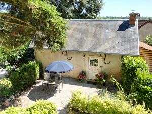 una casa con tavolo, sedie e ombrellone di Charming Cottage in Chateau les Roches gardens a Mont-Saint-Jean