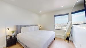 a bedroom with a white bed and a large window at Ocean's Edge Luxury Rentals in Ocean City