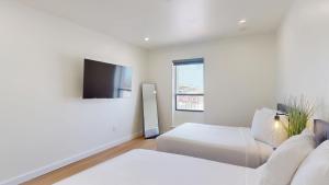 a hotel room with two beds and a flat screen tv at Ocean's Edge Luxury Rentals in Ocean City