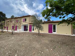 a house with purple doors and a yard at Podere Buriano, Villa with Swimmingpool in Monterotondo