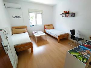 a small room with two beds and a table at Zlatna Boska in Kotor
