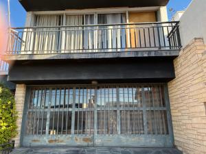 a building with a balcony and a barred gate at El Refugio House in Maipú +2 photos