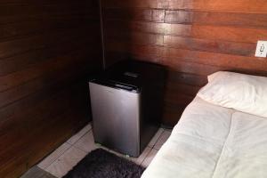 a room with a small refrigerator next to a bed at Cabana do Arqueiro in Campos do Jordão