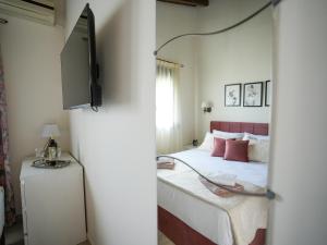 a bedroom with a bed and a tv on a wall at The Garden House in Antimácheia