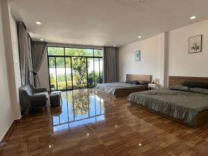 a large bedroom with two beds and a chair at homestay halona in Phu Quoc