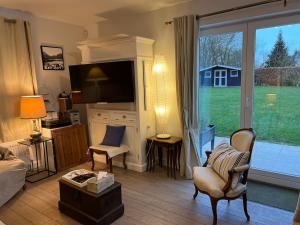 a living room with a couch and a chair and a window at Céline Apartment in Chaumont-Gistoux