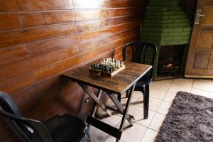 a chess board on a wooden table in a room with a fireplace at Cabana do Arqueiro in Campos do Jordão