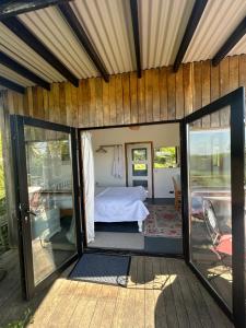 a room with a bed and sliding glass doors at Countryside Garden Summer House in Calne