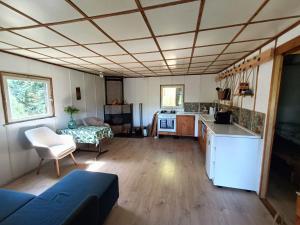 a large room with a kitchen and a living room at SUPy, Krokodyl i Las - domek z balią i prywatnym pomostem in Trzebiechowo