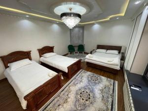 een slaapkamer met 2 bedden en een kroonluchter bij Anoras home in Samarkand +18 foto's