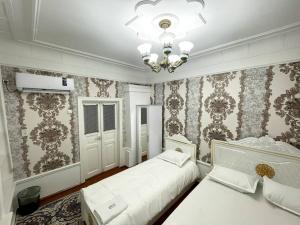 a bedroom with two beds and a chandelier at Anora home in Samarkand