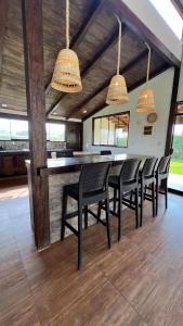 a dining room with a bar with black chairs at Accommodation in Huaral in Huaral