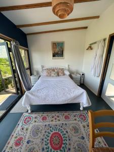 a bedroom with a bed and a rug at Countryside Garden Summer House in Calne