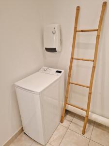 a laundry room with a white refrigerator and a ladder at Grand F1 sécurisé hypercentre calme 3mins de la gare in Thionville
