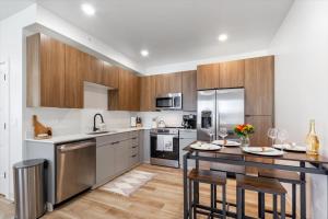 a kitchen with stainless steel appliances and wooden cabinets at Teton Mountain Nest in Driggs