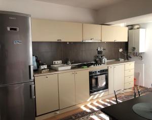 a kitchen with white cabinets and a stainless steel refrigerator at Central Hill Reșița in Reşiţa