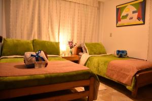 a hotel room with two beds and a couch at Casa campestre la Posada de Leo in Paipa
