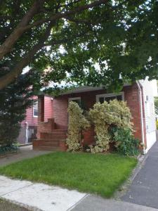 a red brick house with a bush on the front at 3 Bedroom House 2 Bath House Near New York in Clifton