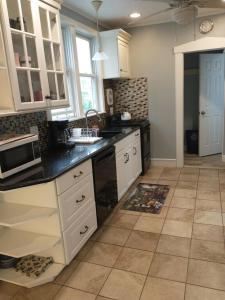 a kitchen with white cabinets and a black counter top at 3 Bedroom House 2 Bath House Near New York in Clifton