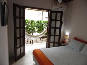 a bedroom with a bed and an open door at Pousada Barra Vento in Morro de São Paulo