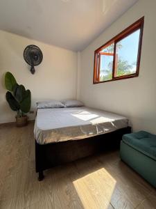 una camera con letto, finestra e divano di Casa Jaguar - Cabin Near Playa del Viento a San Bernardo del Viento