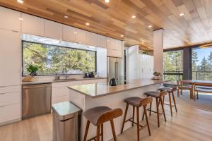 a kitchen with a large island with bar stools at Stunning Modern Mountain Home for 10 in Truckee New Hot Tub BBQ Close to Slopes Book on Mobile for Promo Price in Truckee