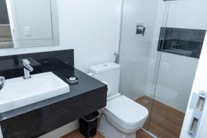 a bathroom with a toilet and a sink and a shower at Guaja 745 - Apartamento Teca in Belo Horizonte