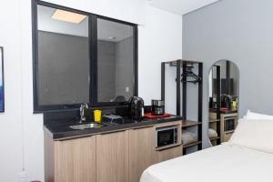 Un baño con lavabo, espejo y cama. en Guaja 745 - Apartamento Teca, en Belo Horizonte
