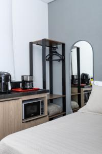 una habitación de hotel con una cama y un espejo en Guaja 745 - Apartamento Teca, en Belo Horizonte