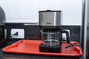 a blender sitting on a red tray on a counter at Guaja 745 - Apartamento Teca in Belo Horizonte