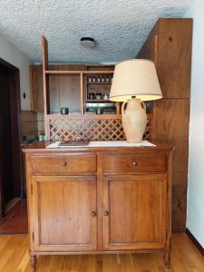 a lamp on top of a wooden cabinet in a kitchen at Philia Dolomiti, Folgarida in Folgarida